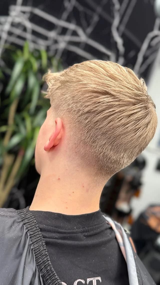 Blonde slicked-back cut with a low taper, back view